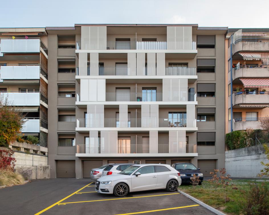 Photographie d'un immeuble avec son parking